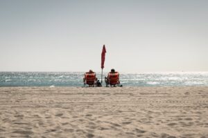 people sitting in chairs at the beach, ocean, shore, best places to live in florida